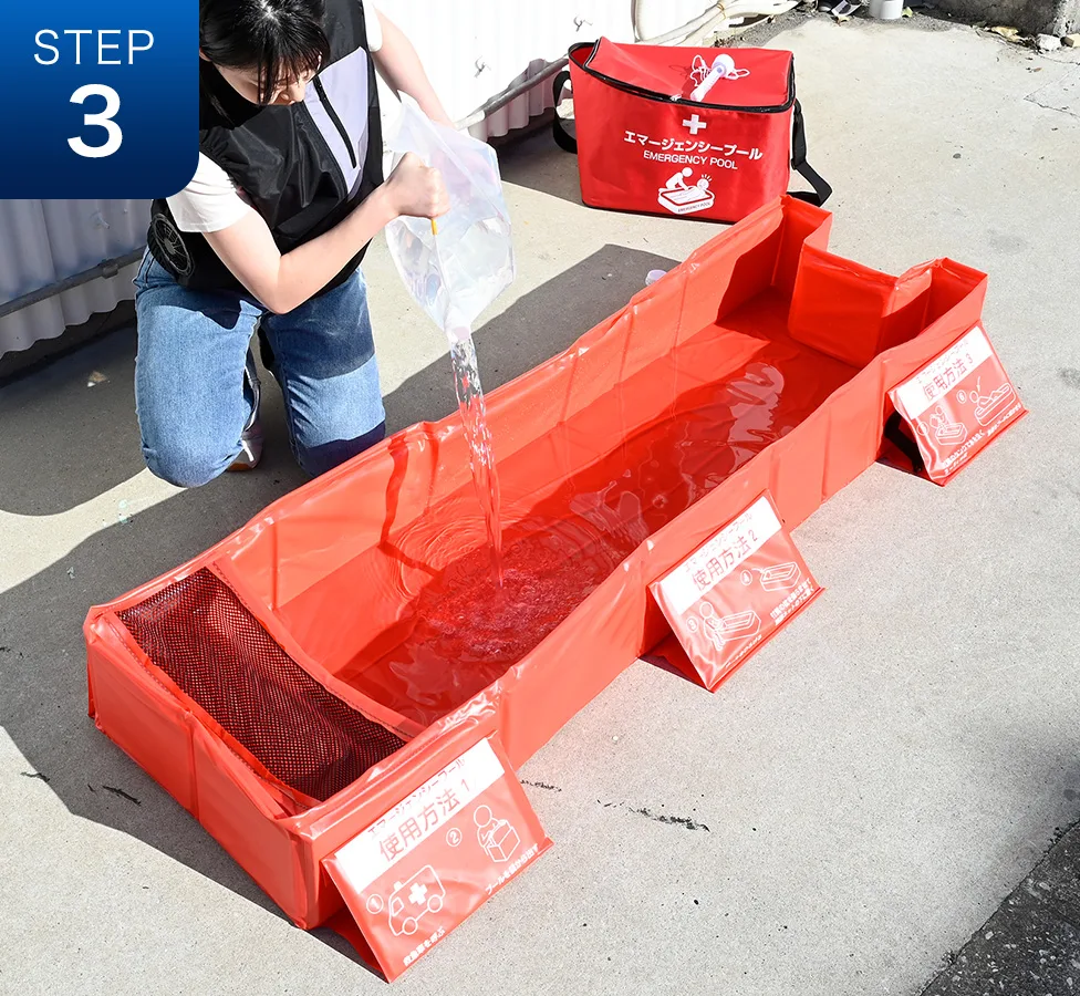 ポリタンクでプールに水を入れている様子